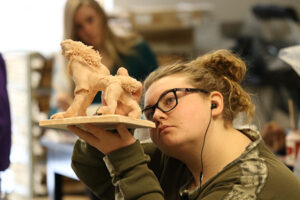 art student inspects their sculpture